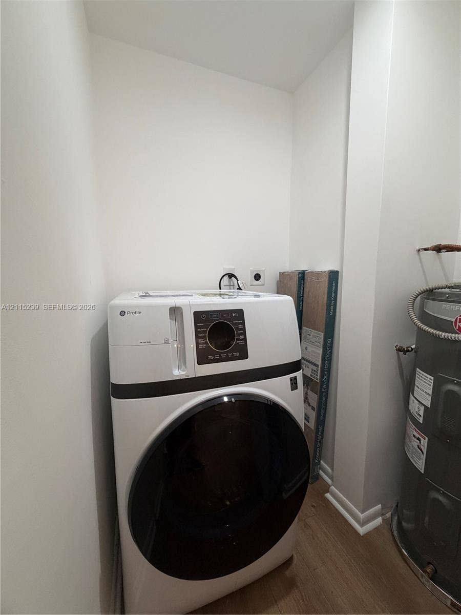 9015 SW 138th Street, #16-2, Miami, Miami, FL 33176 Utility area featuring wood-finish flooring, white walls, and a built-in electric water heater