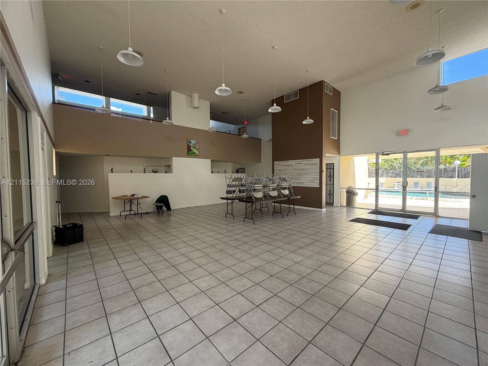 9015 SW 138th Street, #16-2, Miami, Miami, FL 33176 Expansive interior featuring high ceilings, ceramic tile flooring, abundant natural light from clerestory windows, and glass-paneled doors
