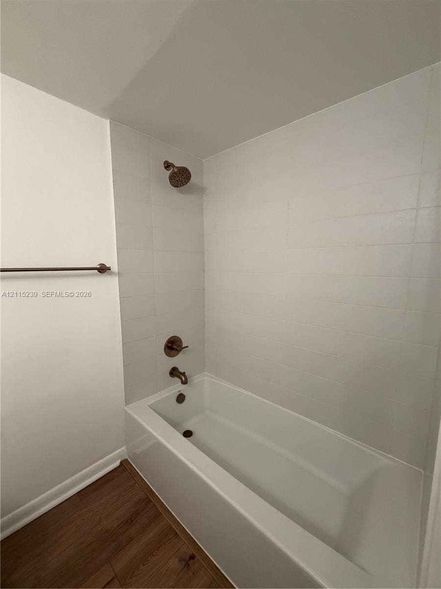 9015 SW 138th Street, #16-2, Miami, Miami, FL 33176 Full-size bathtub featuring white rectangular wall tile, bronze-finish fixtures, and wood-finish flooring