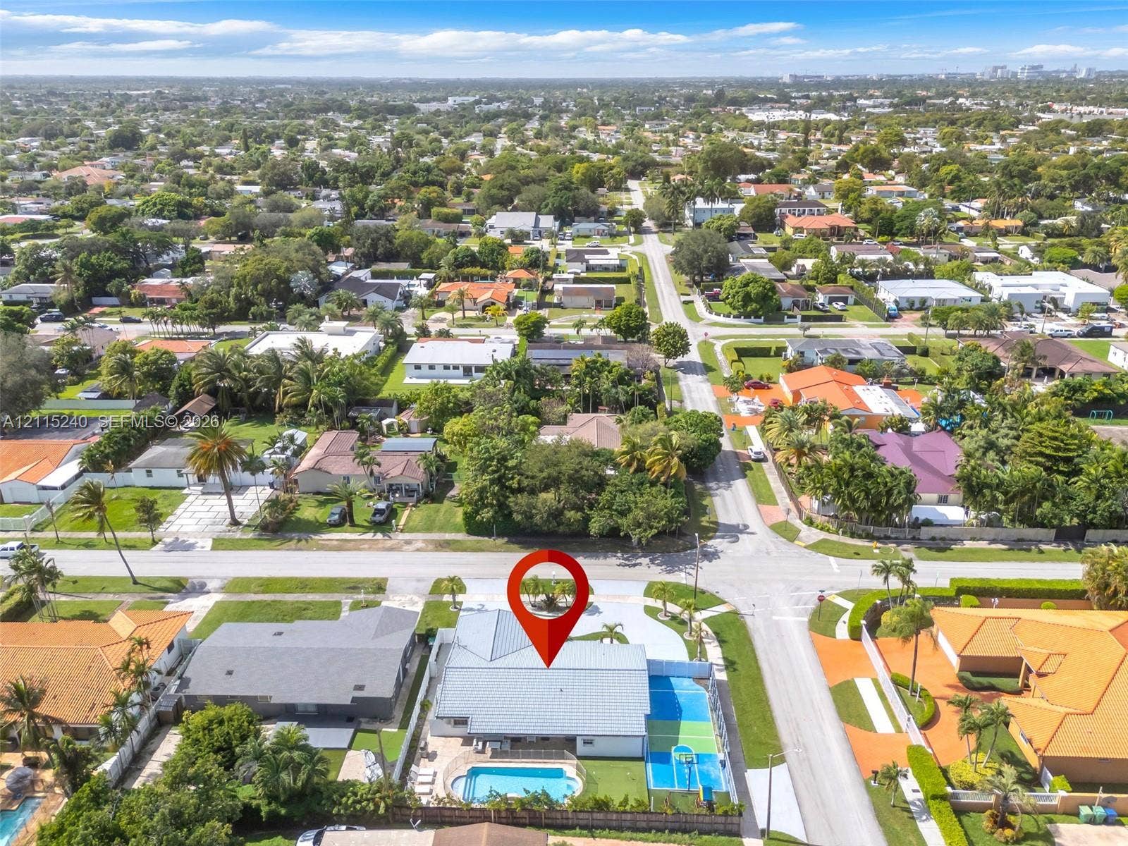Corner lot property featuring a private swimming pool, multi-use hardscaped sports court, and concrete tile roofing