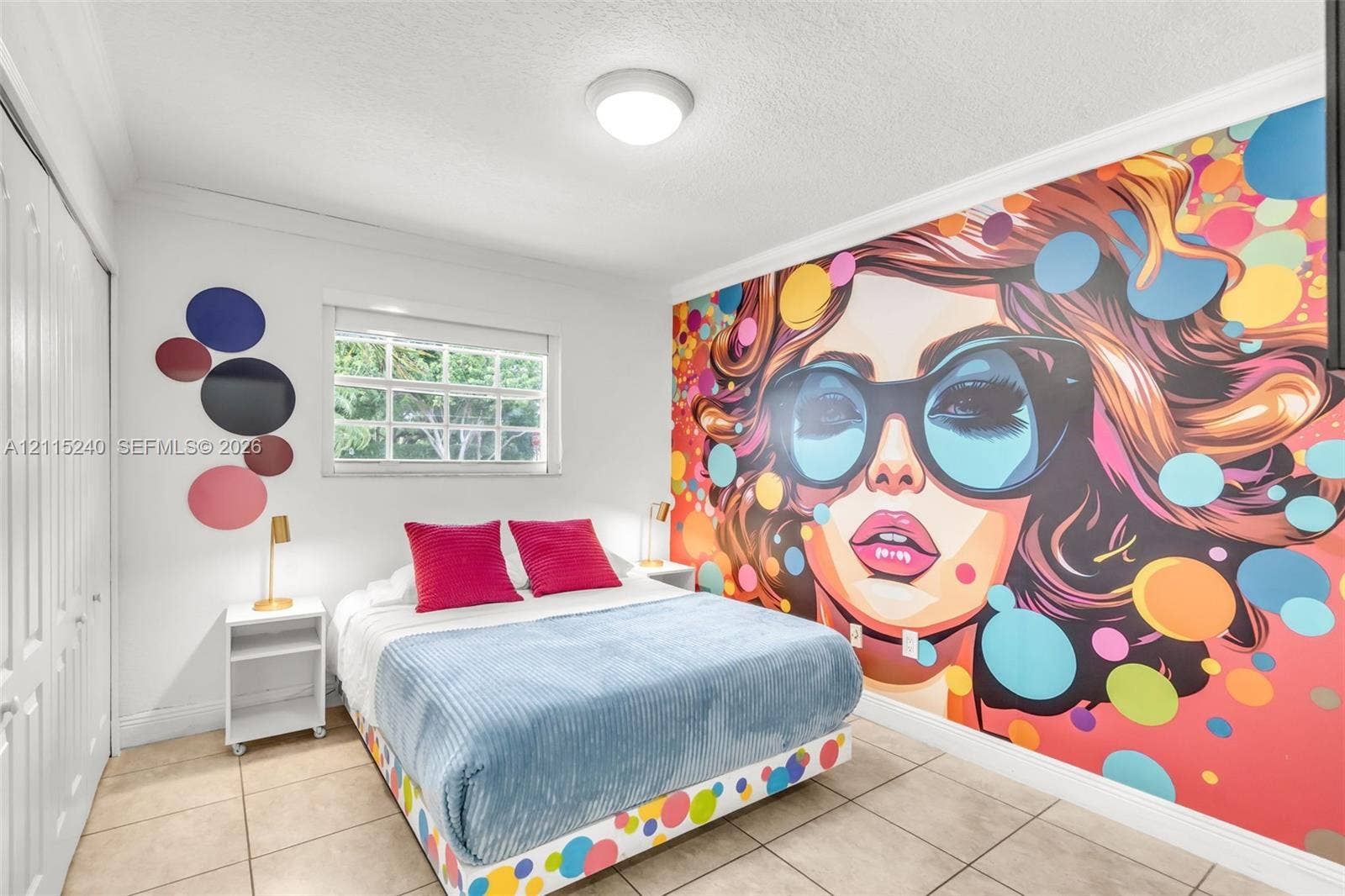 Room featuring large-scale wall mural, tiled flooring, multi-pane window, and double-door closet