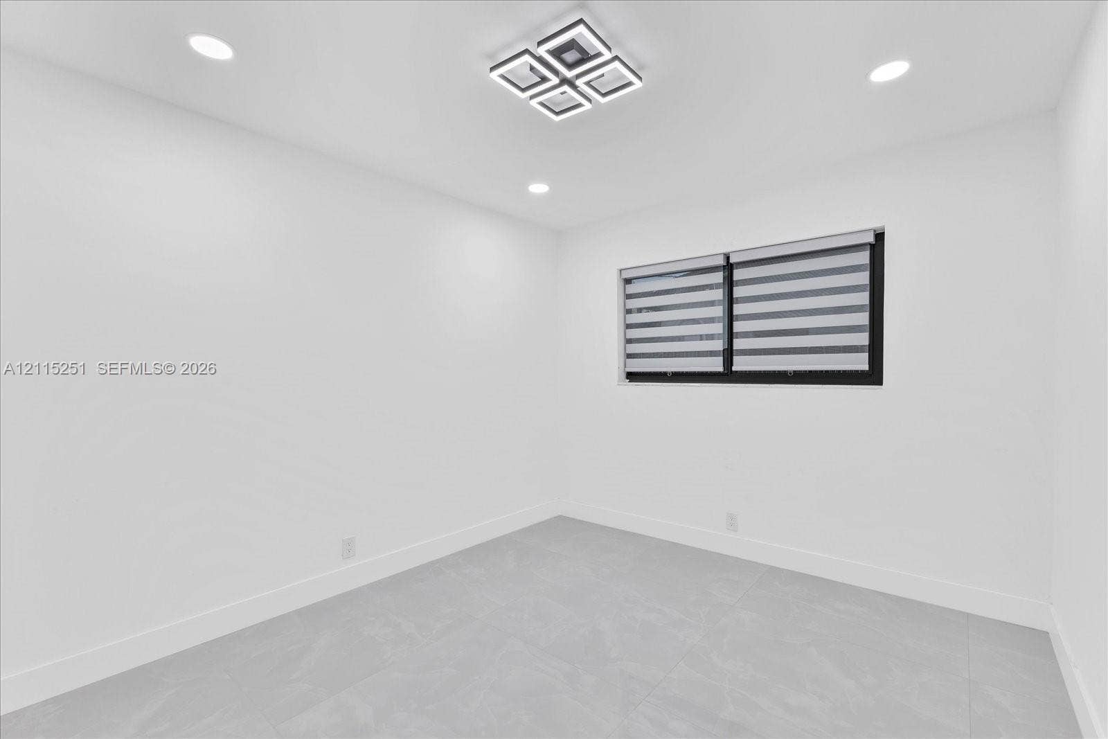 19511 NE 18th Place, Miami, FL 33179 Neutral-toned tile flooring, geometric LED flush-mount lighting, recessed ceiling lights, and window with dark frame
