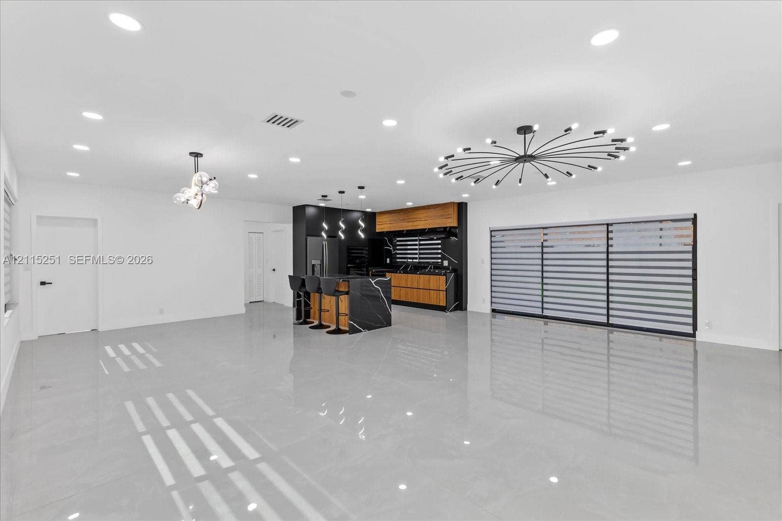 19511 NE 18th Place, Miami, FL 33179 Open-concept kitchen featuring two-toned cabinetry, a stone-surface waterfall island, recessed lighting, and large-format tile flooring