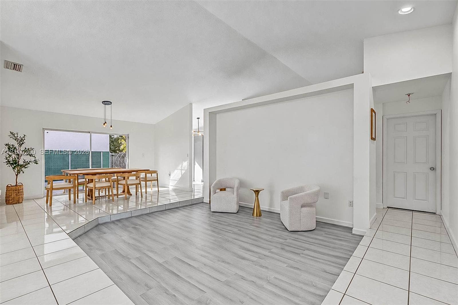 820 NW 132nd Court, Miami, FL 33182 Sunken living area featuring wood-finish flooring, white tile flooring, vaulted ceilings, recessed lighting, and sliding glass doors