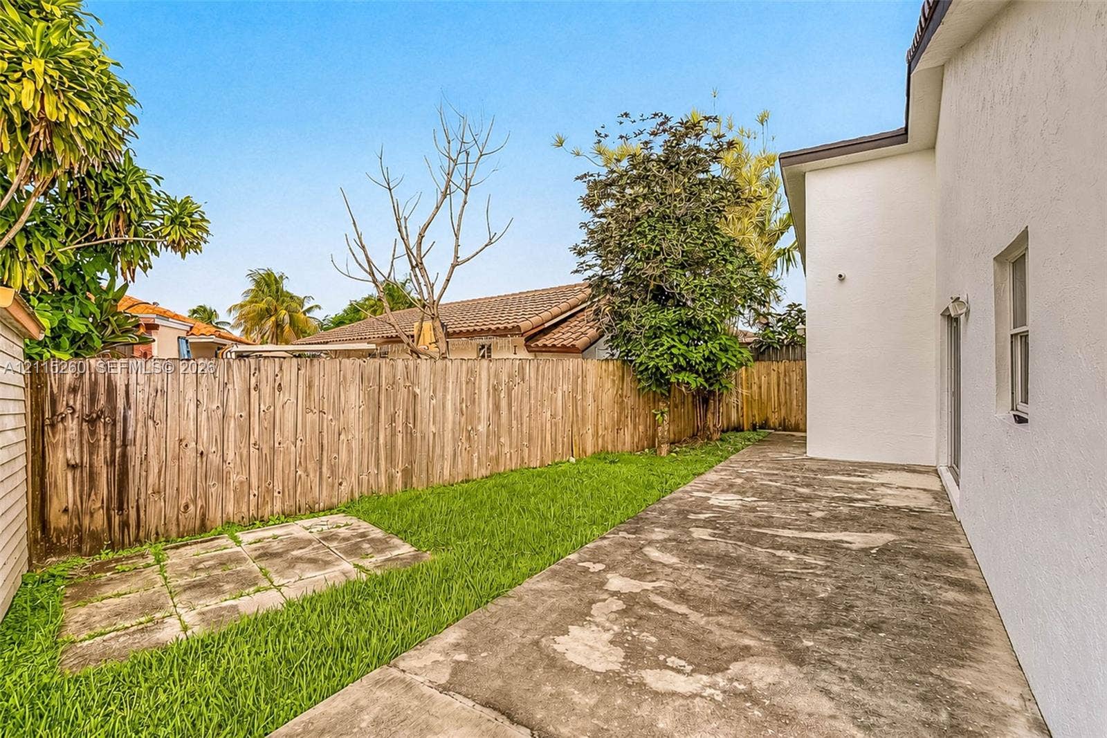 820 NW 132nd Court, Miami, FL 33182 Private backyard featuring a concrete patio, a grass lawn, and wood privacy fencing