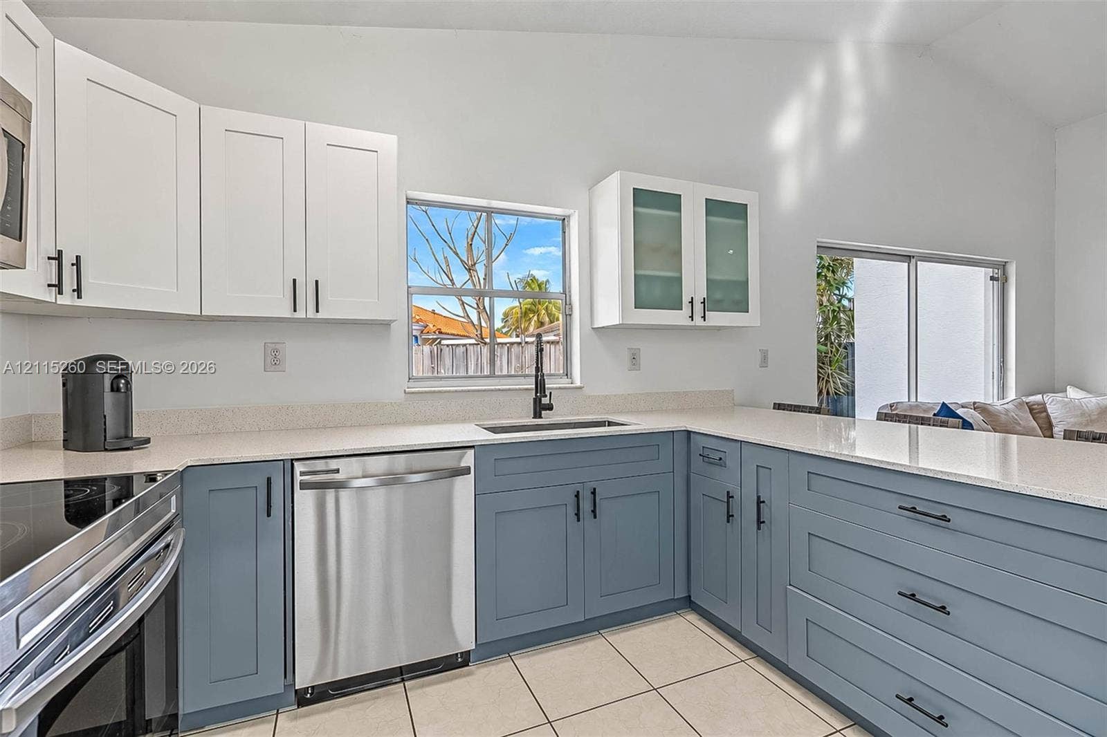 820 NW 132nd Court, Miami, FL 33182 Kitchen featuring two-tone cabinetry with matte black hardware, stone-composite countertops, stainless steel dishwasher, glass-front upper cabinets, and tile flooring