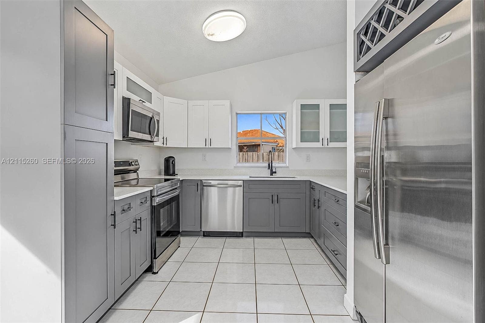 820 NW 132nd Court, Miami, FL 33182 Kitchen featuring two-tone shaker cabinetry, solid-surface countertops, stainless steel appliances, ceramic tile flooring, and integrated wine storage