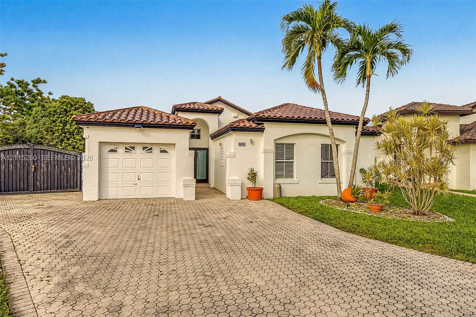 820 NW 132nd Court, Miami, FL 33182 Stucco exterior residence featuring a barrel tile roof, paver driveway, single-car garage, and arched entryway