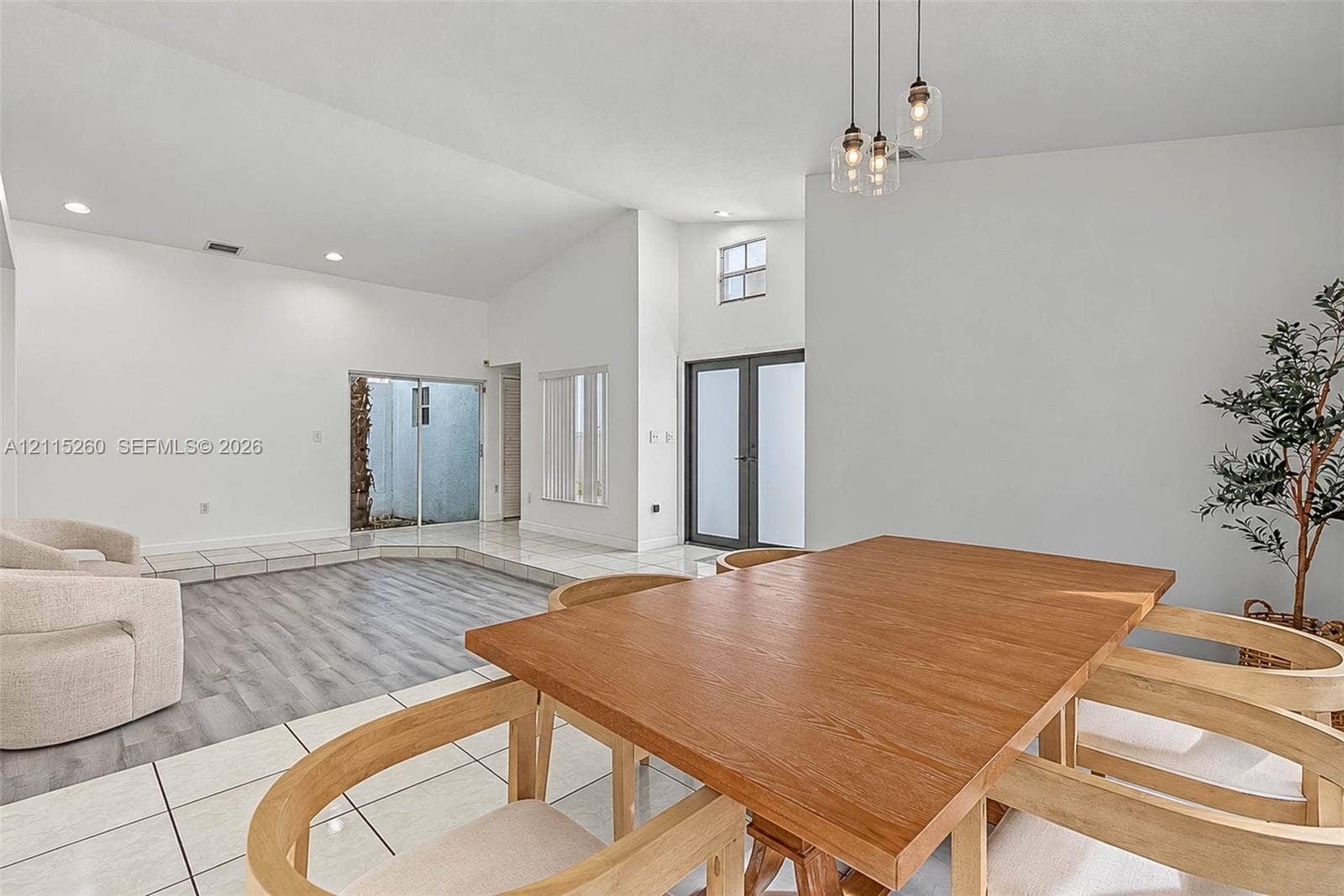 820 NW 132nd Court, Miami, FL 33182 Vaulted ceilings with recessed lighting, wood-finish flooring, large-format tile flooring, multi-pane glass entry doors, and triple-pendant glass lighting fixtures