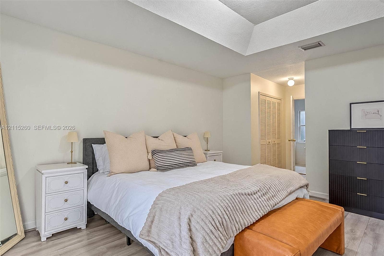 820 NW 132nd Court, Miami, FL 33182 Tray ceiling featuring crisp white paint, louvered bi-fold closet doors, and wood-finish flooring