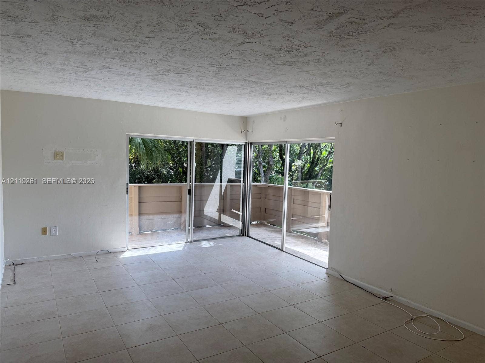 1205 Mariposa Avenue, #302, Coral Gables, Coral Gables, FL 33146 Neutral-toned ceramic tile flooring, dual sliding glass doors, and access to a wood-railed exterior balcony