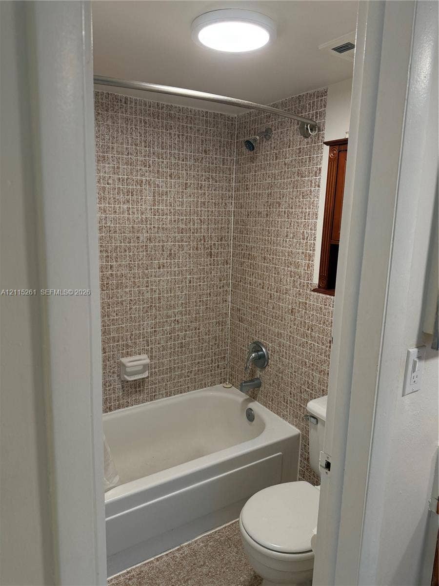 1205 Mariposa Avenue, #302, Coral Gables, Coral Gables, FL 33146 Bathroom featuring a soaking tub, mosaic tile surround, chrome fixtures, and flush-mount ceiling lighting