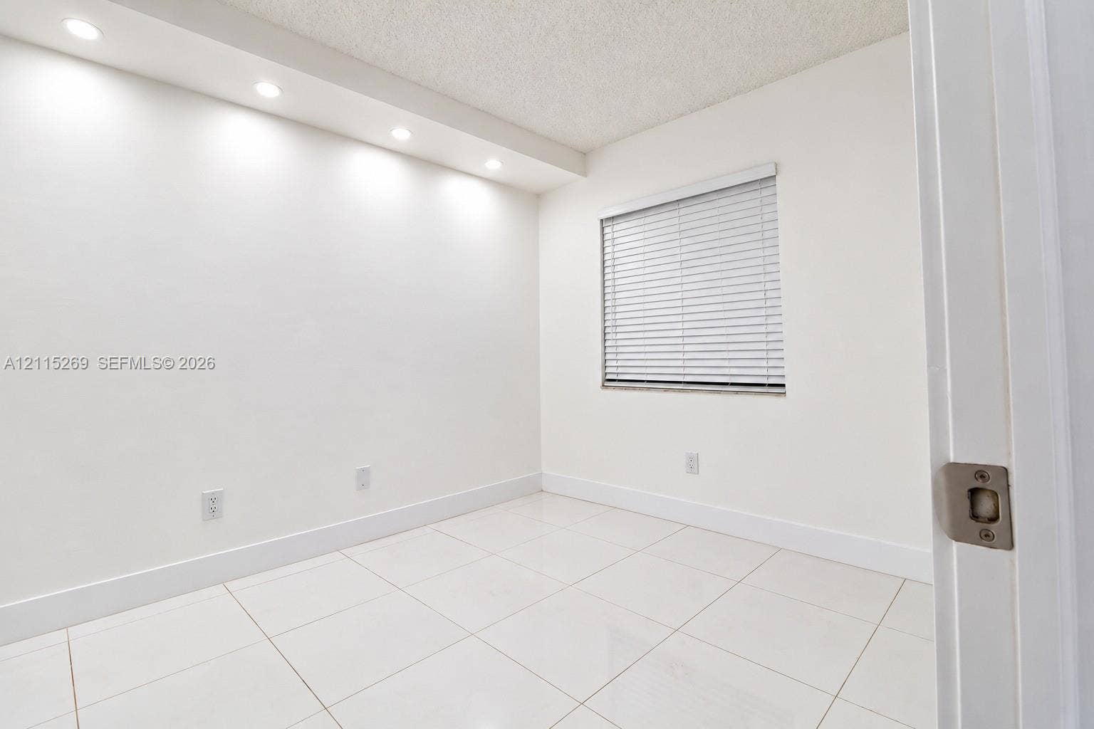 8615 NW 8th Street, #211, Miami, Miami, FL 33126 Room featuring large-format ceramic tile flooring, recessed cove lighting, and a single window with horizontal blinds