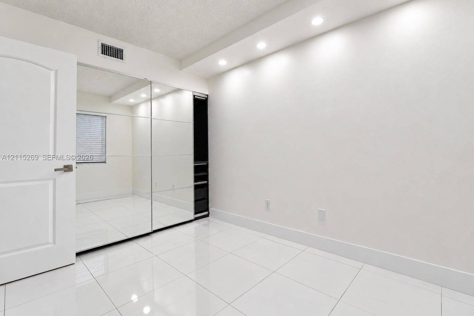 8615 NW 8th Street, #211, Miami, Miami, FL 33126 Wall-to-wall mirrored closet doors, recessed ceiling lighting, glossy tiled flooring, and built-in closet shelving