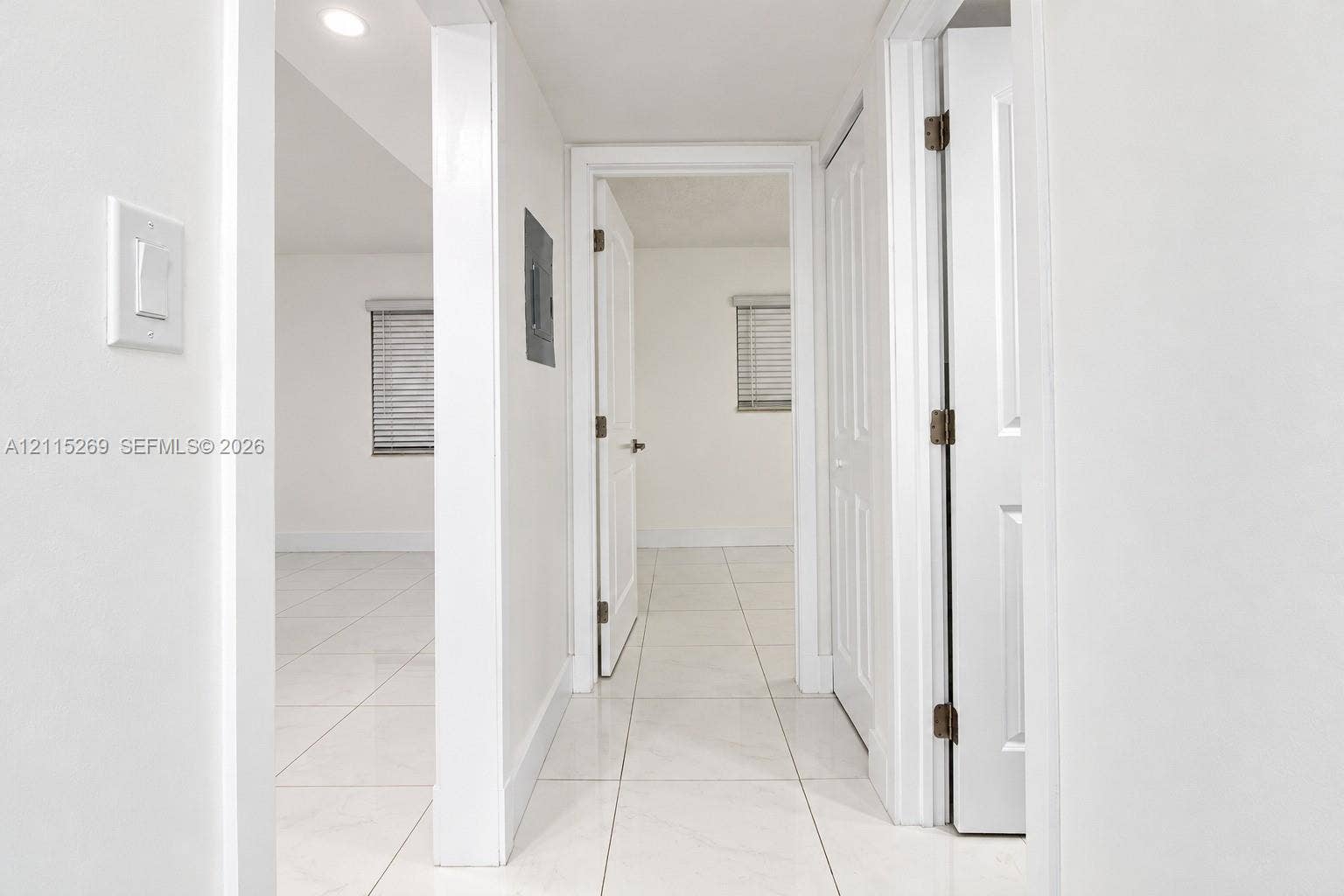 8615 NW 8th Street, #211, Miami, Miami, FL 33126 Neutral-toned interior featuring large-format ceramic tile flooring, recessed lighting, white six-panel doors, and white-framed windows with horizontal blinds