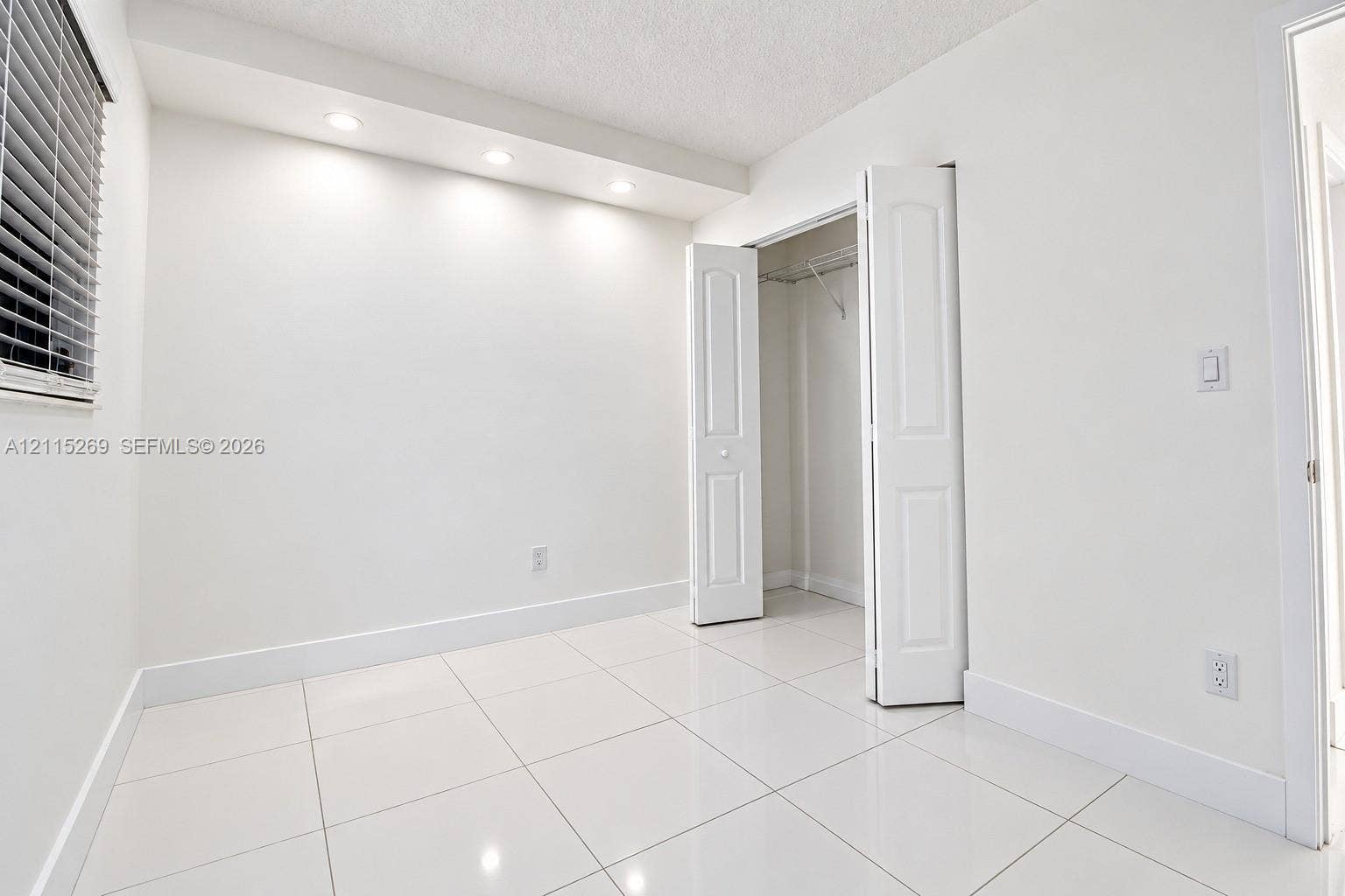 8615 NW 8th Street, #211, Miami, Miami, FL 33126 Glossy tile flooring, recessed ceiling lighting, and a closet with bifold doors