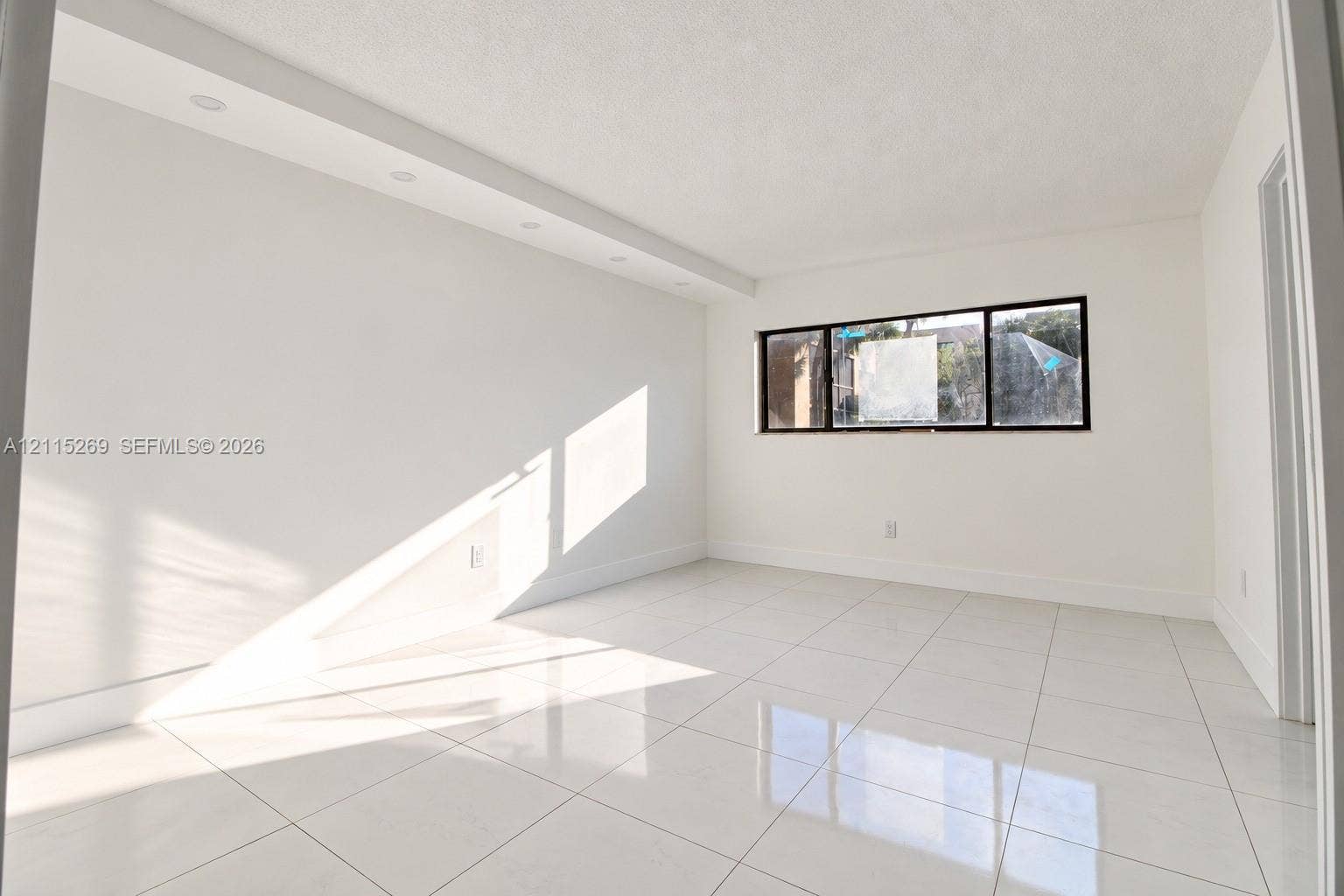 8615 NW 8th Street, #211, Miami, Miami, FL 33126 Bright interior space featuring polished tile flooring, recessed ceiling lighting, and a window with a black frame