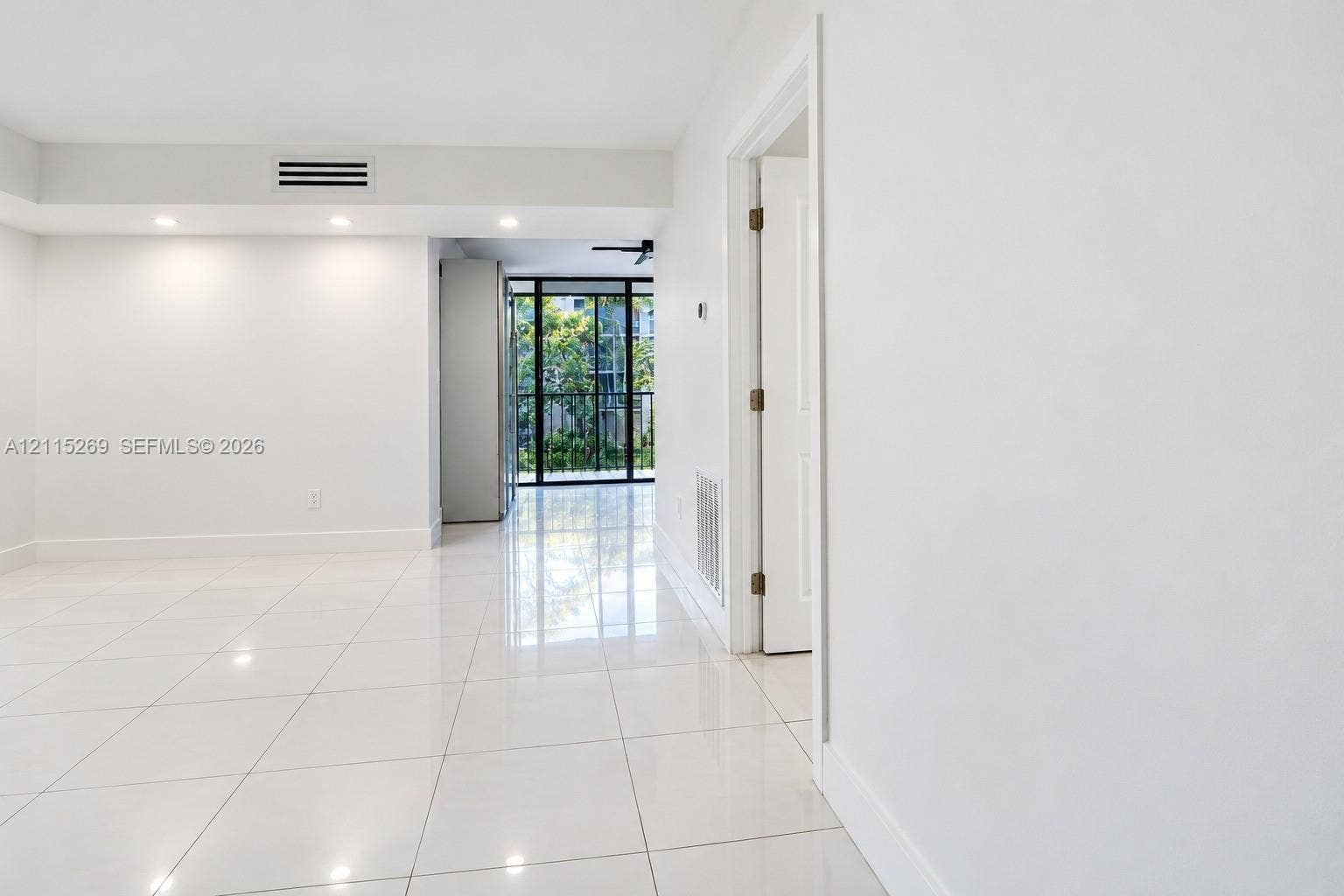8615 NW 8th Street, #211, Miami, Miami, FL 33126 Glossy white tile flooring, recessed ceiling lighting, and floor-to-ceiling glass-paneled sliding doors
