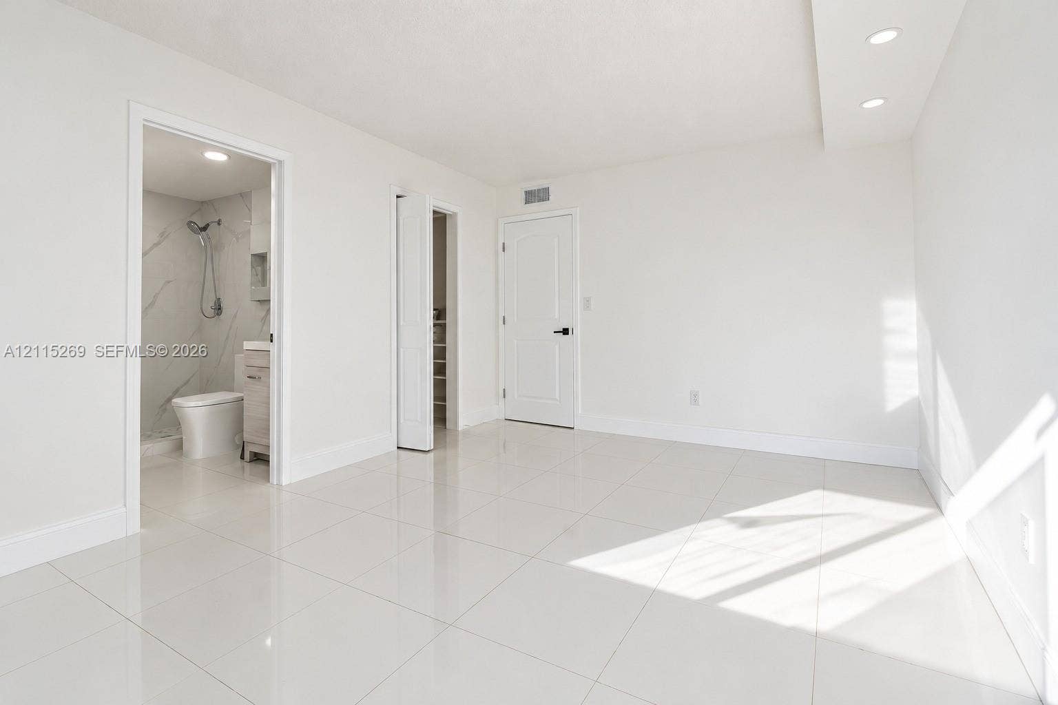 8615 NW 8th Street, #211, Miami, Miami, FL 33126 Interior space featuring large-format tile flooring, recessed ceiling lighting, a dedicated closet with a folding door, and an attached bathroom with a walk-in shower