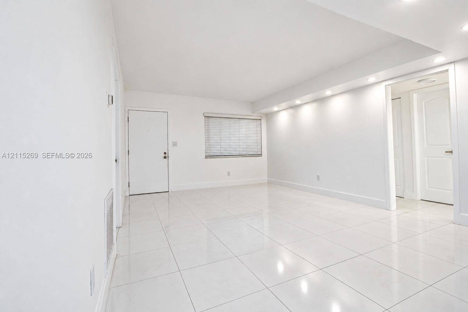 8615 NW 8th Street, #211, Miami, Miami, FL 33126 Interior space featuring high-gloss tile flooring, recessed ceiling lighting, smooth white walls, and a recessed window with horizontal blinds