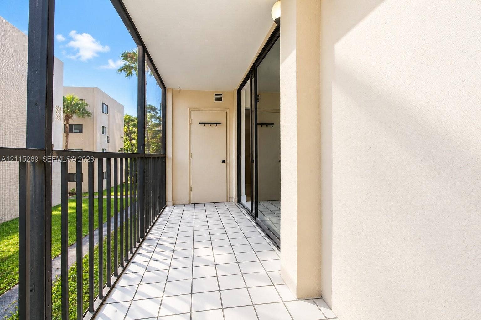 8615 NW 8th Street, #211, Miami, Miami, FL 33126 Screened-in balcony featuring tile flooring, metal railing, and a private storage closet