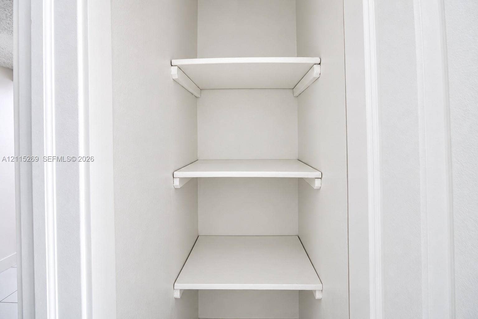 8615 NW 8th Street, #211, Miami, Miami, FL 33126 Built-in storage closet featuring three fixed white shelves and bracket supports