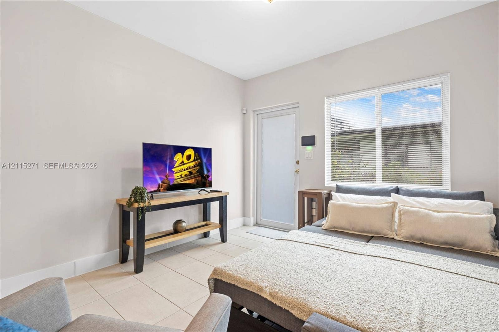 Neutral wall tones, ceramic tile flooring, single-lite glass entry door, and large dual-pane window