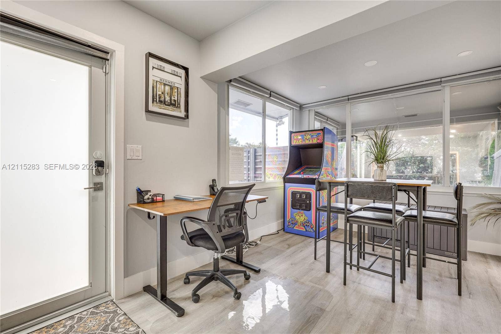 1619a NE 25th Street, #A, Wilton Manors, Wilton Manors, FL 33305 Full-light glass exterior door featuring a smart lock, light-tone wood-finish flooring, recessed ceiling lighting, and expansive floor-to-ceiling windows