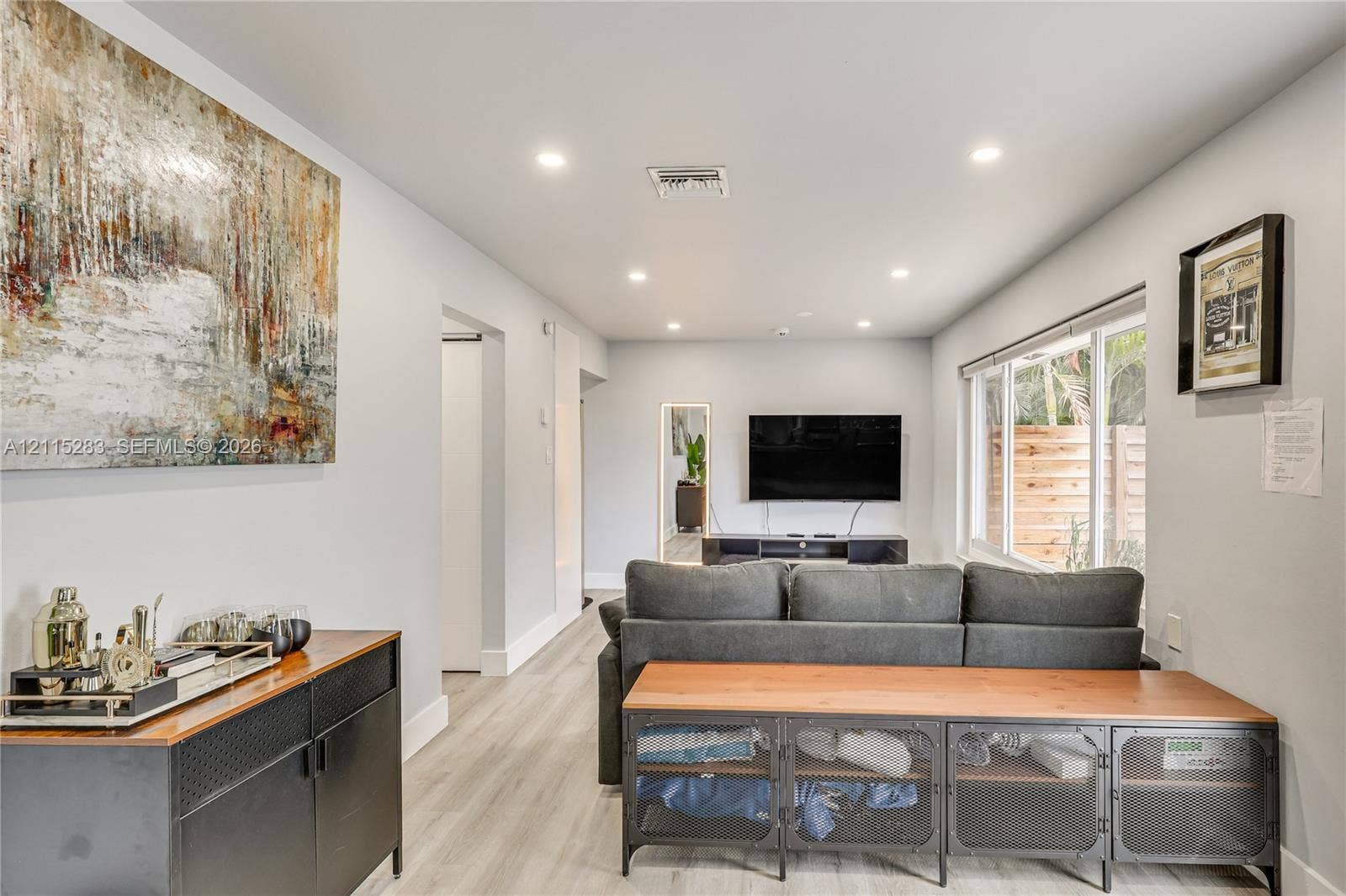 1619a NE 25th Street, #A, Wilton Manors, Wilton Manors, FL 33305 Interior space featuring light-toned wood-finish flooring, recessed lighting, and large windows with horizontal blinds