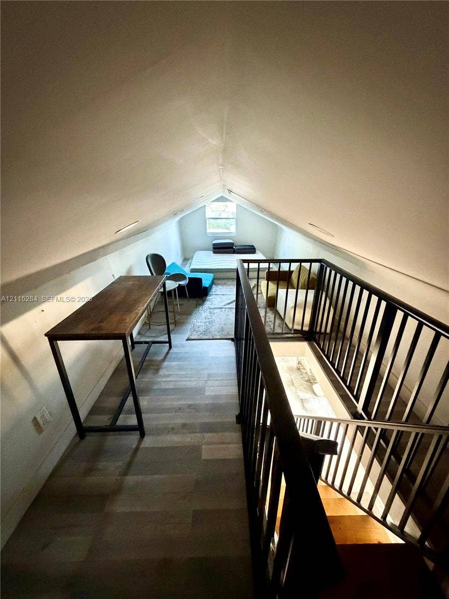 8047 NW 1st Place, Miami, Miami, FL 33150 Vaulted ceiling featuring a steeply pitched roofline, wood-finish flooring, and a black metal spindle railing