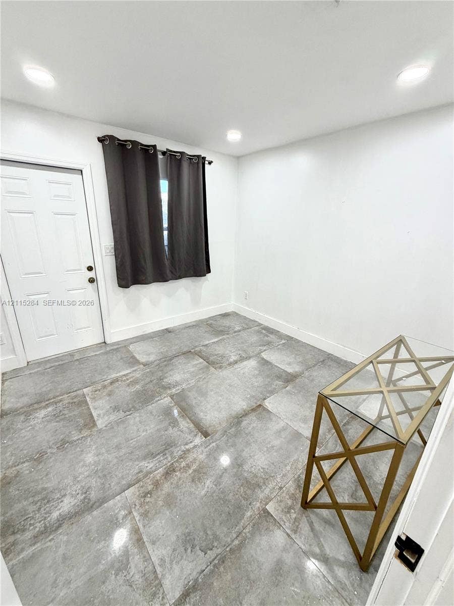 8047 NW 1st Place, Miami, Miami, FL 33150 Large-format gray stone-finish floor tiling, recessed ceiling lighting, and a solid-core six-panel door with metallic hardware