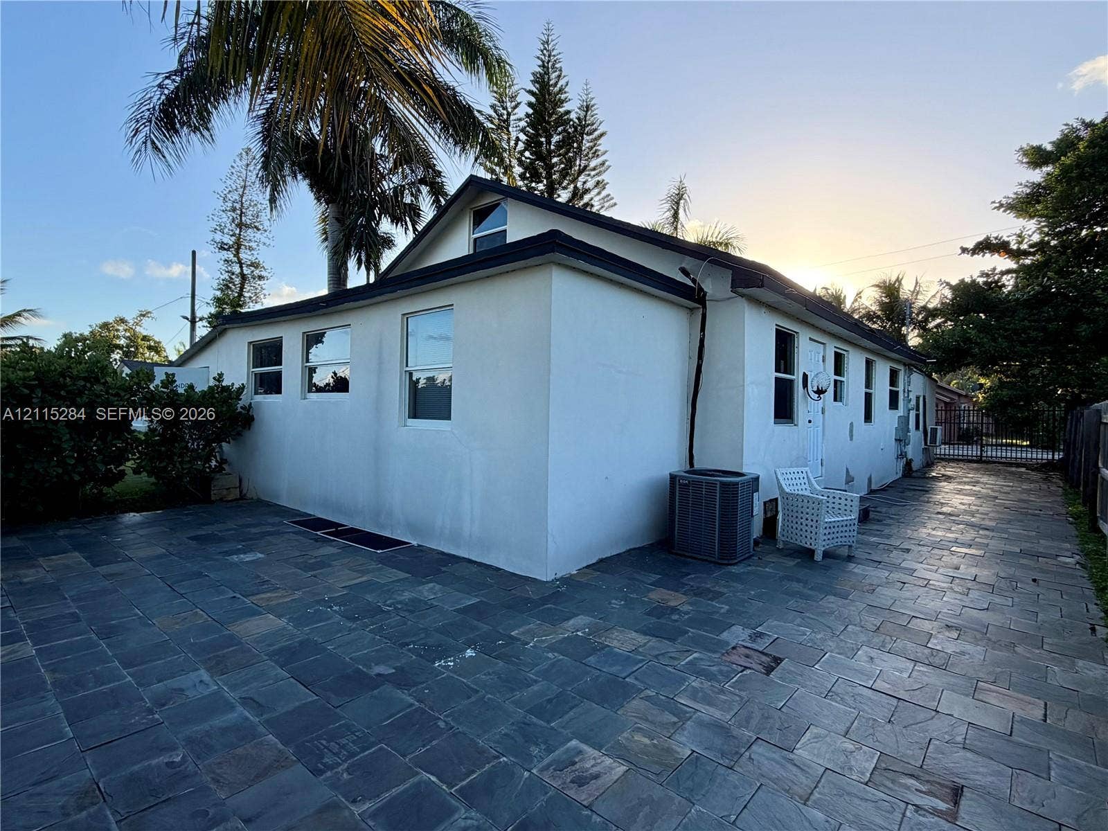 8047 NW 1st Place, Miami, Miami, FL 33150 Exterior featuring smooth stucco siding, multi-pane windows, and extensive natural stone paver hardscaping
