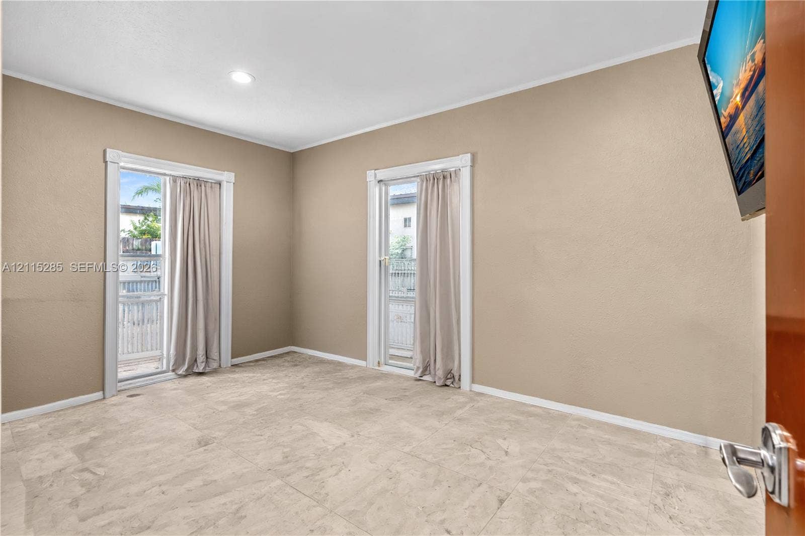 14221 Carver Drive, Miami, FL 33176 Neutral-toned room featuring large-format tile flooring, recessed ceiling lighting, and two glass-paned doors with white trim