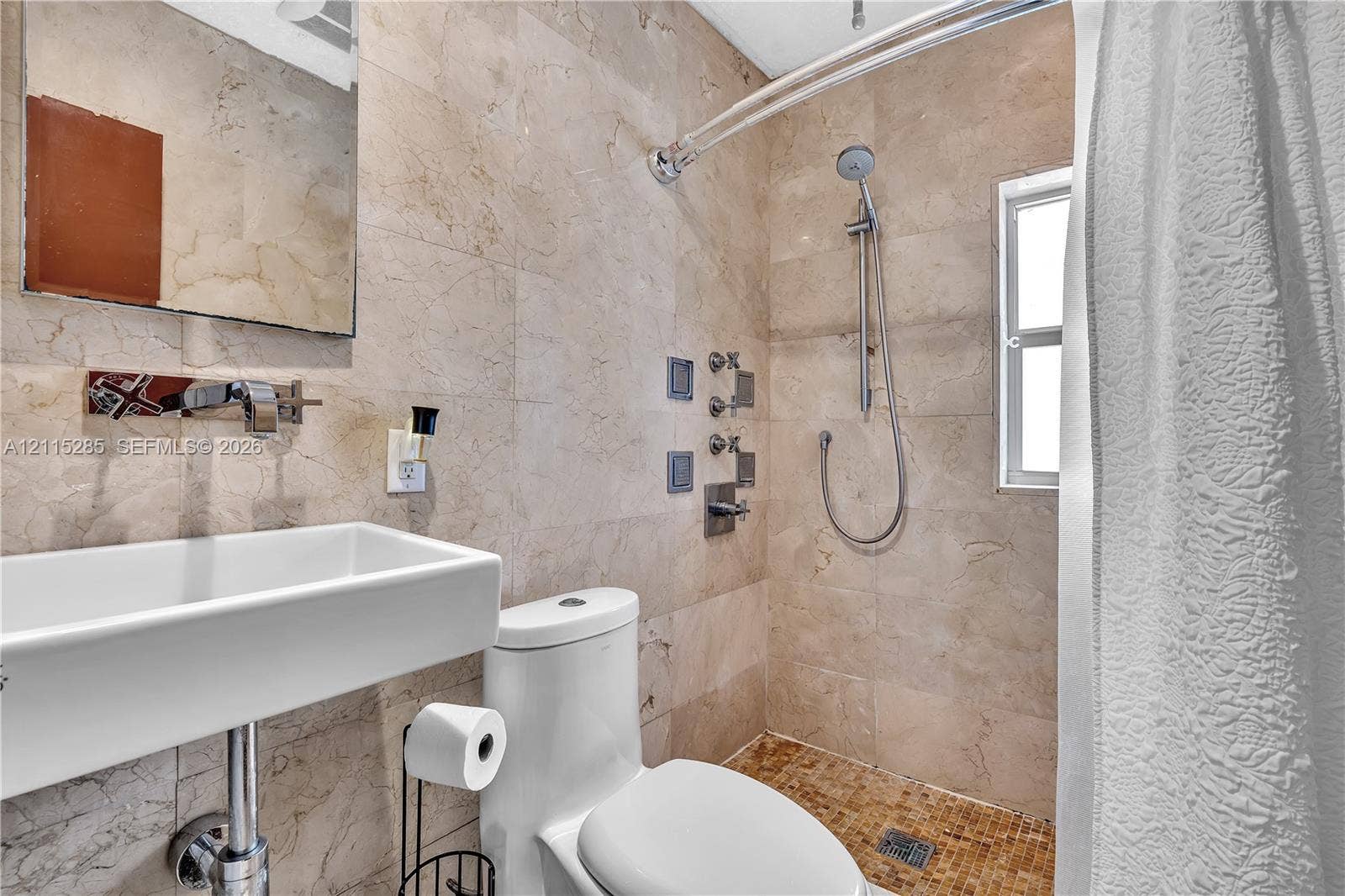 14221 Carver Drive, Miami, FL 33176 Bathroom featuring stone tile walls, a wall-mounted rectangular vessel sink with a chrome faucet, and a shower system with integrated wall jets and a handheld sprayer