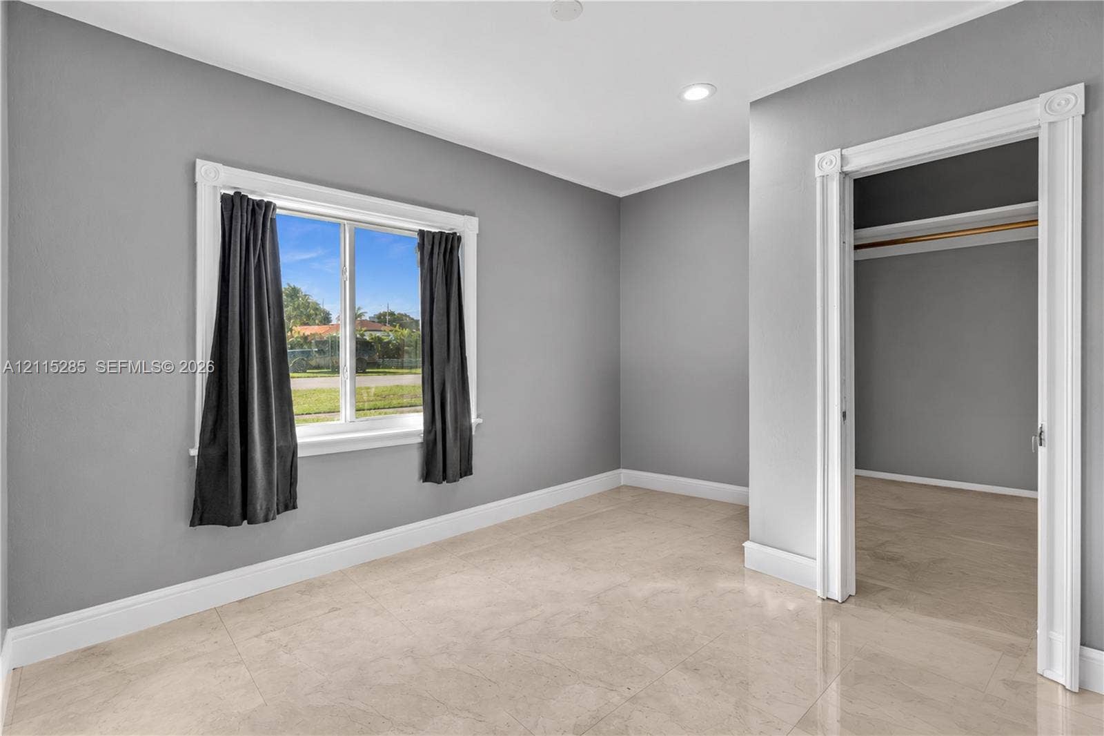 14221 Carver Drive, Miami, FL 33176 Neutral-toned interior space featuring polished tile flooring, crisp white casing around the doorway and window, and recessed ceiling lighting