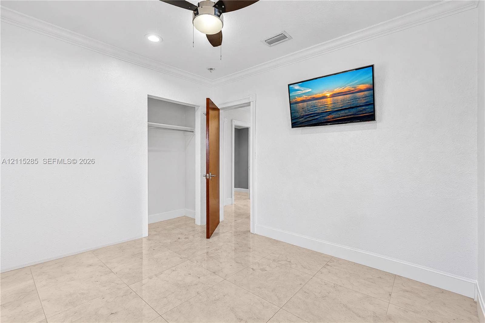 14221 Carver Drive, Miami, FL 33176 Neutral-toned tile flooring, crown molding, ceiling fan with integrated lighting, and built-in closet storage