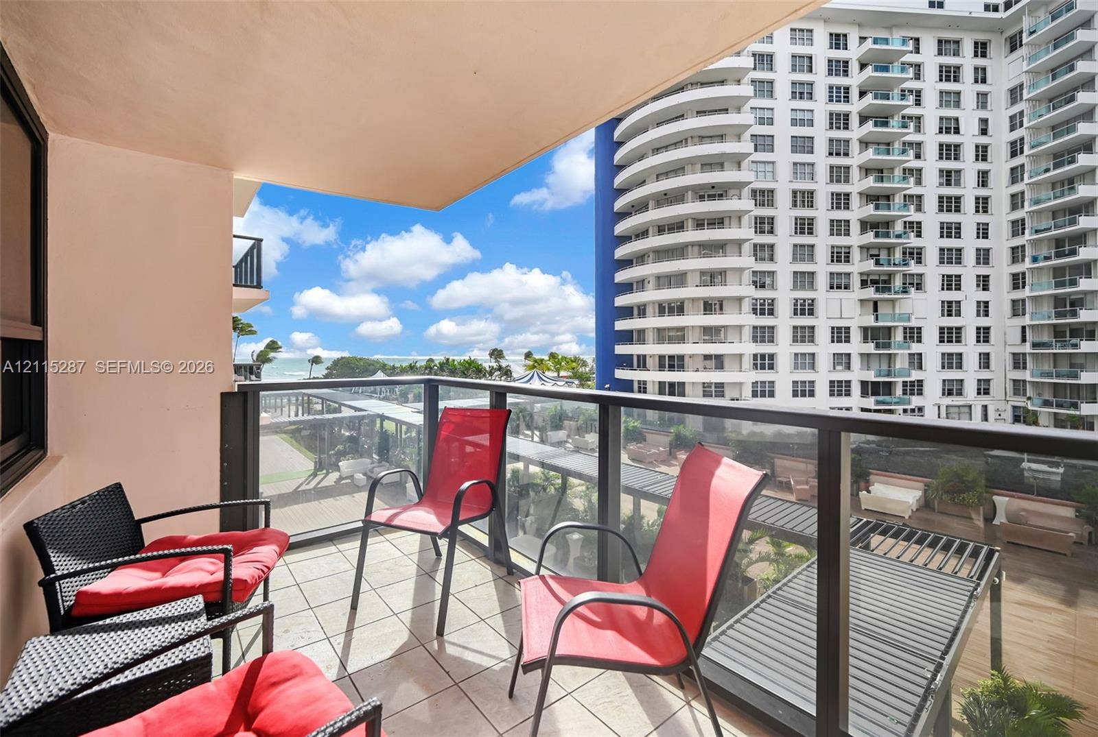 5225 Collins Avenue, #511, Miami Beach, FL 33140 Covered balcony featuring tile flooring and a glass-paneled railing