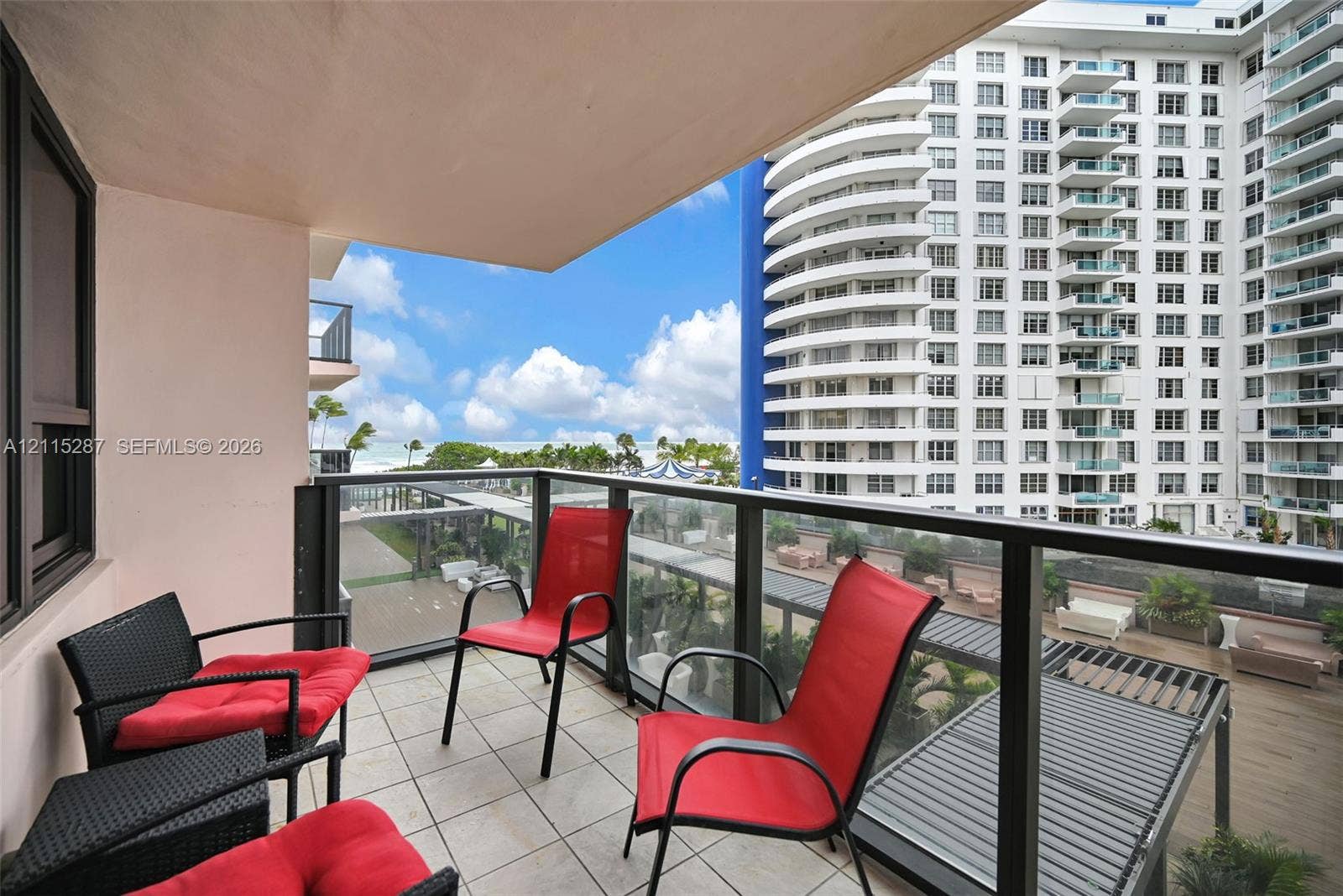 5225 Collins Avenue, #511, Miami Beach, FL 33140 Covered balcony featuring tile flooring and a glass-paneled railing