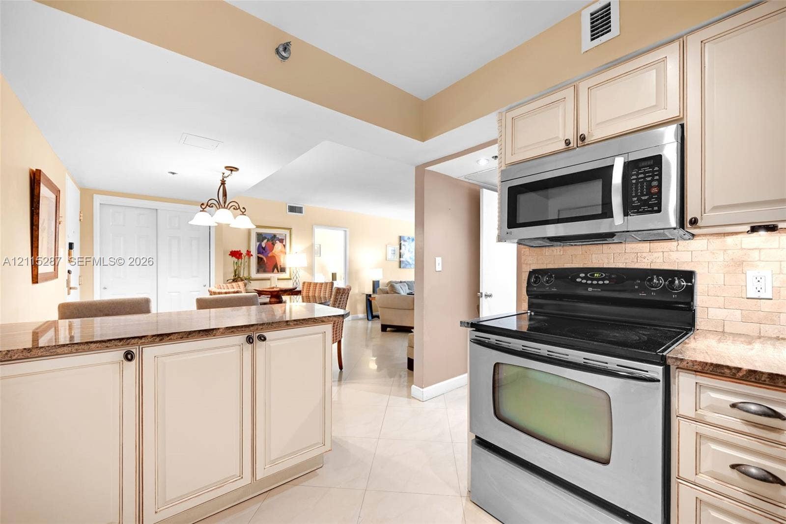 5225 Collins Avenue, #511, Miami Beach, FL 33140 Kitchen featuring stainless steel appliances, neutral cabinetry, stone-finish countertops, tiled backsplash, and ceramic floor tiling