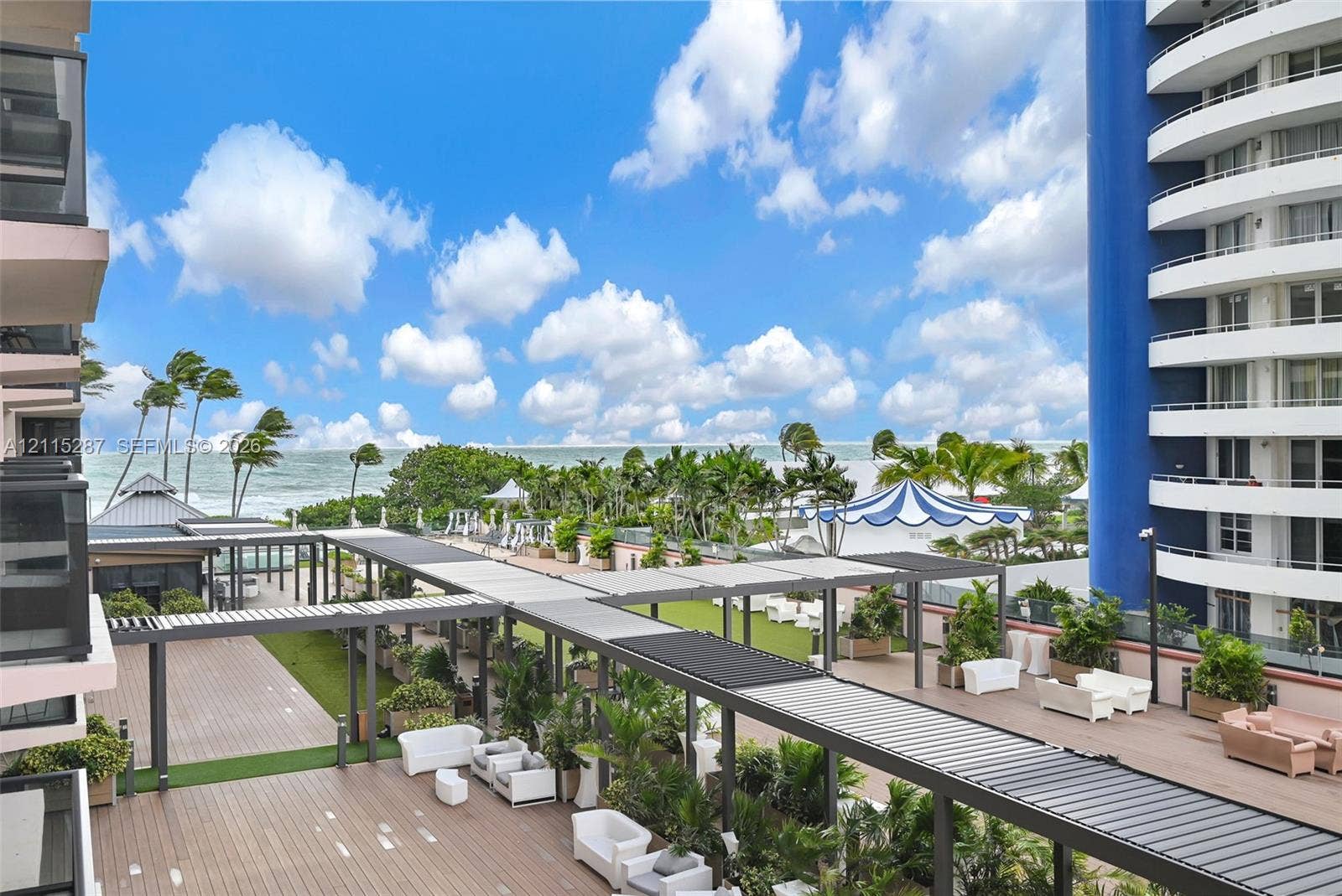5225 Collins Avenue, #511, Miami Beach, FL 33140 Expansive elevated terrace featuring wood-finish decking, integrated metal pergola structures, built-in landscape planters, and oceanfront exposure