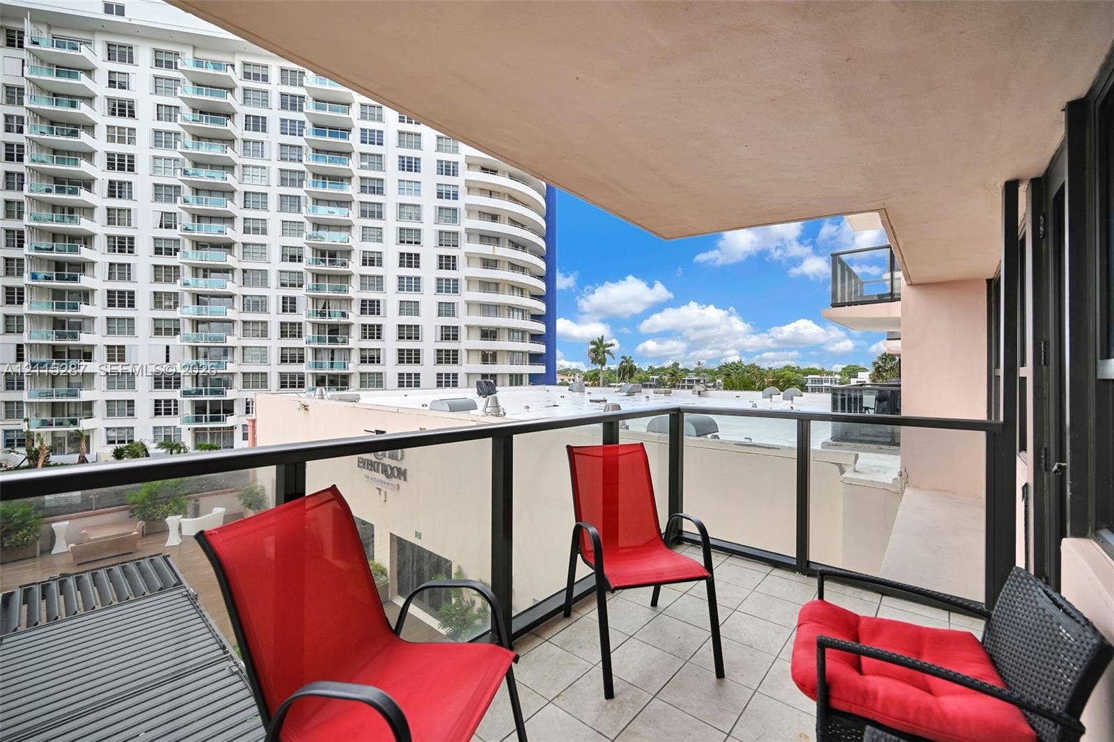 5225 Collins Avenue, #511, Miami Beach, FL 33140 Covered balcony featuring tile flooring and a glass panel railing