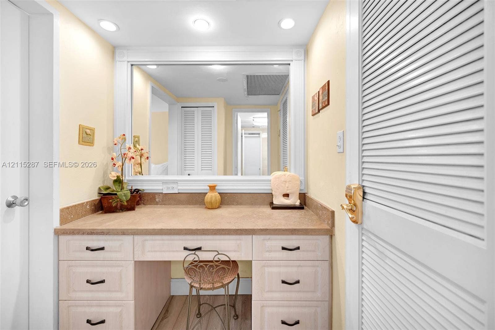 5225 Collins Avenue, #511, Miami Beach, FL 33140 Built-in vanity featuring a stone-finish countertop, light-toned cabinetry, recessed lighting, and an expansive wall-mounted mirror with decorative trim
