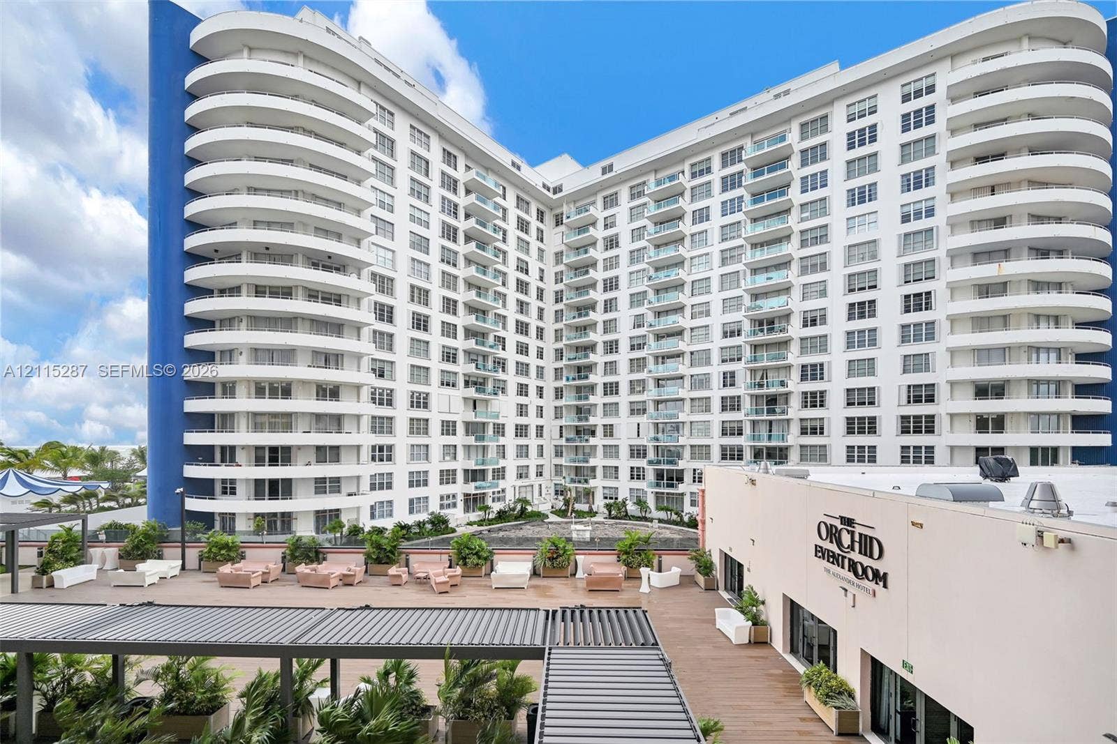 5225 Collins Avenue, #511, Miami Beach, FL 33140 Multi-story high-rise building featuring rounded wrap-around balconies, a structured expansive terrace, integrated metal pergolas, and built-in landscape planters