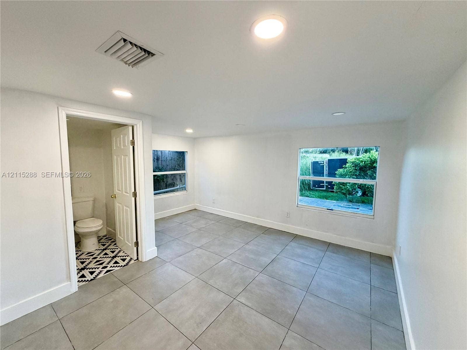 8017 NW 1st Place, Miami, Miami, FL 33150 Interior space featuring neutral wall tones, large-format tile flooring, recessed ceiling lighting, and windows with exterior exposure