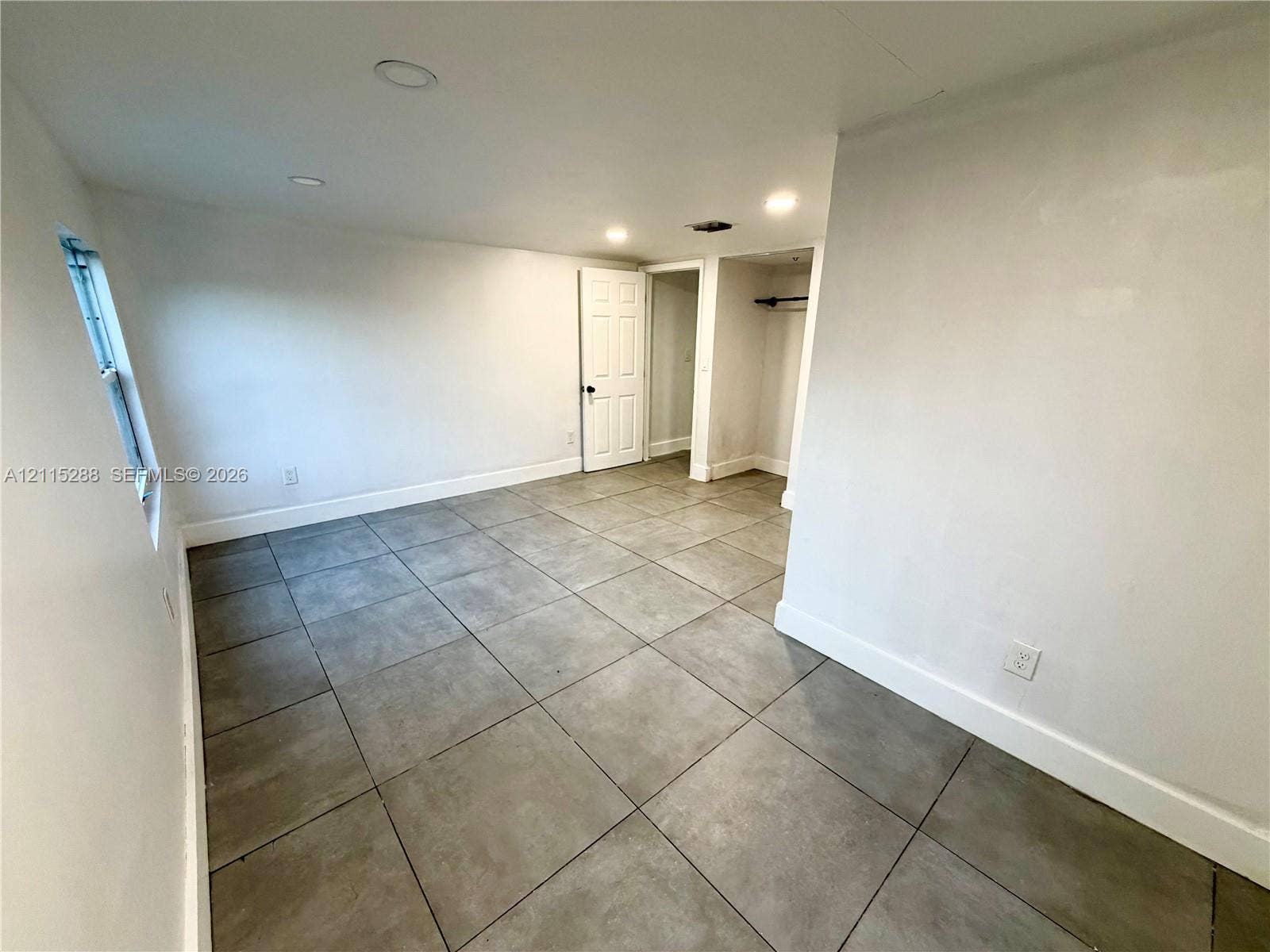 8017 NW 1st Place, Miami, Miami, FL 33150 Neutral-toned interior featuring large-format square floor tiles, recessed ceiling lighting, and a walk-in closet with a built-in clothing rod