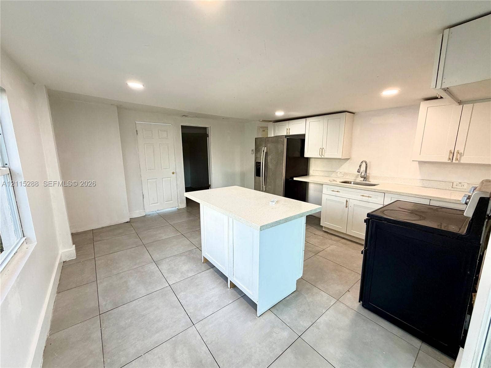 8017 NW 1st Place, Miami, Miami, FL 33150 Kitchen featuring white shaker-style cabinetry, quartz countertops, a central island, recessed lighting, and tile flooring
