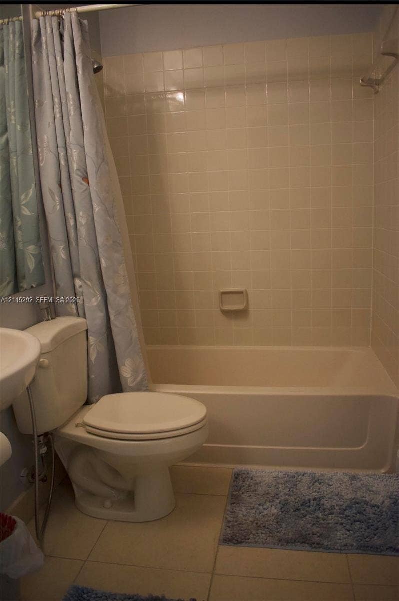 2700 SW 55th Street, #1, Dania, Dania Beach, FL 33312 Bathroom featuring a tub-shower combination with tiled surround, a porcelain pedestal sink, and large-format floor tile