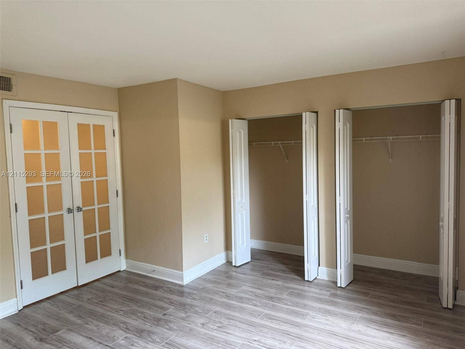2642 NW 33rd Street, #1902, Oakland Park, Oakland Park, FL 33309 Double French doors with glass panes, wood-finish flooring, and two reach-in closets featuring bi-fold doors and built-in shelving