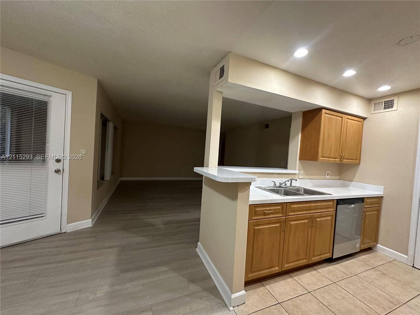 2642 NW 33rd Street, #1902, Oakland Park, Oakland Park, FL 33309 Kitchen featuring light-finish cabinetry, solid-surface countertops, a dual-basin stainless steel sink, a stainless steel dishwasher, and tile flooring