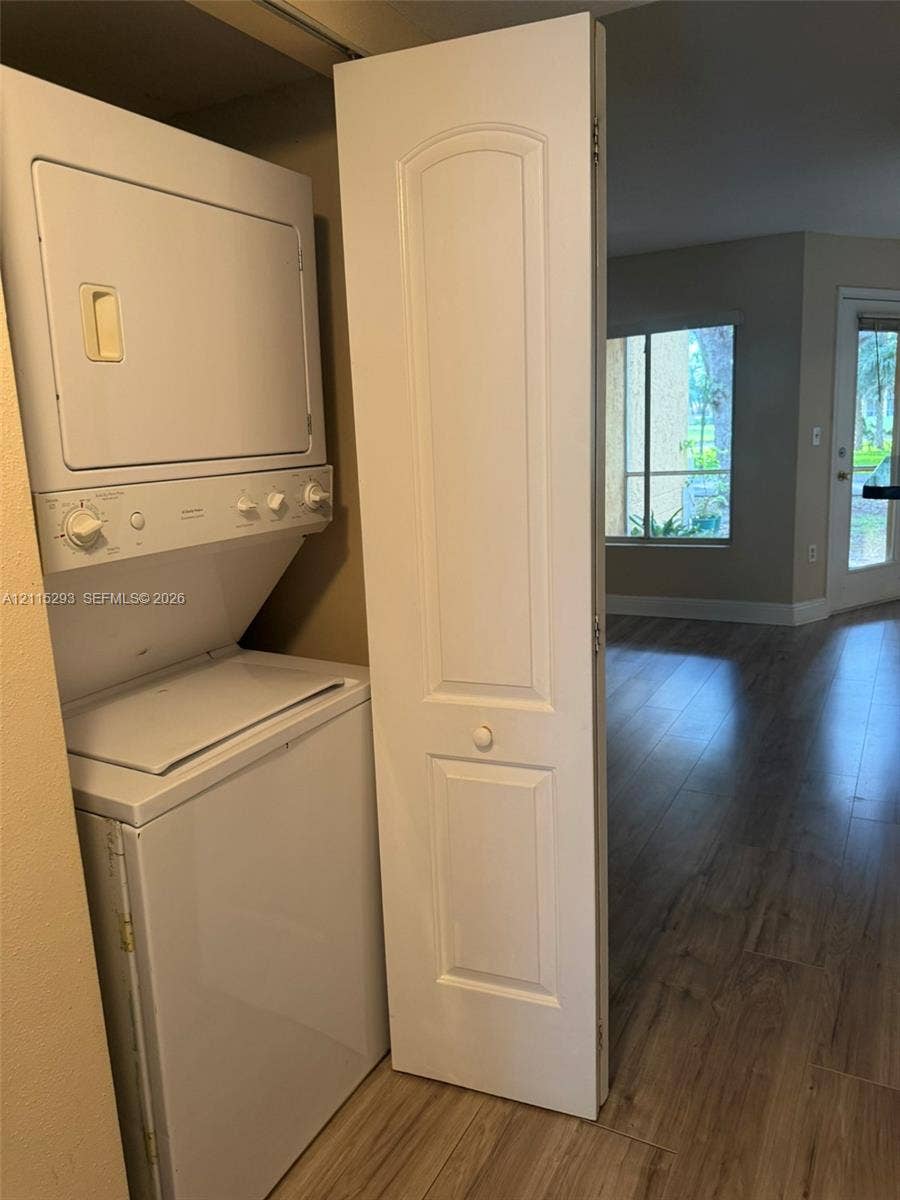 2642 NW 33rd Street, #1902, Oakland Park, Oakland Park, FL 33309 Stacked laundry unit enclosed by a two-panel hinged door, featuring wood-finish flooring throughout